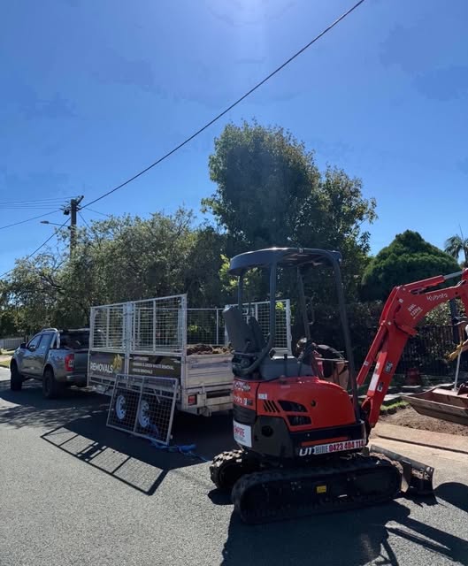 A tipper truck and an excavator parked on a cleared work site